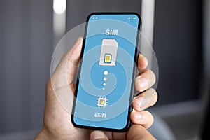 male hands hold phone with Sim card replacement on eSim