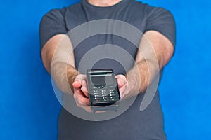 Male hands hold a terminal to pay by credit card. Offering to pay