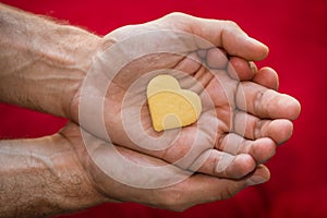 Male hands holding biscuit heart