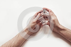 Male hands holding a bottle of perfume