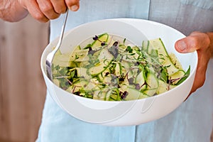 Male hands holding bowl with alternative vegetable homemade zucchini pasta.