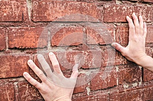 Male hands holding a brick wall. Deadend. photo