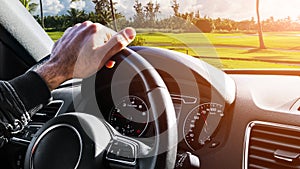 Male hands holding car steering wheel. Hands on steering wheel of a car driving. Young Man driving a car inside cabin