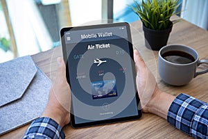 Male hands holding computer tablet with airplane ticket application airlines