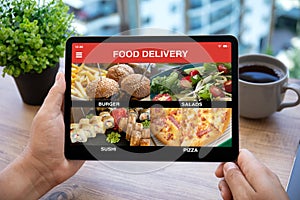 Male hands holding computer tablet with with app food delivery