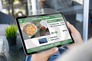 male hands holding computer tablet with app food delivery screen