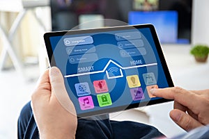 Male hands holding computer tablet with app smart home