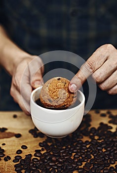 Male hands holding cookie and coffee cup