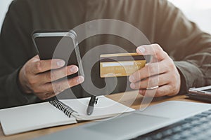 Male hands holding a credit card and use mobile phone for Online payment online shopping