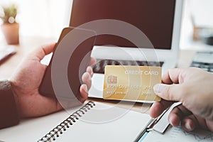 Male hands holding a credit card and use mobile phone for Online payment online shopping