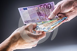 Male hands holding euro banknotes and the other hand to receive a bribe