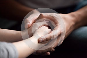 Male hands holding female, giving psychological support concept,