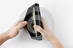 male hands holding a leather wallet with US Dollars cash inside on white background.