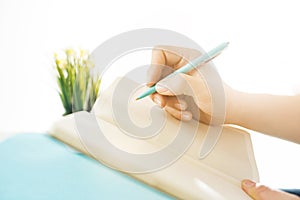 The male hands holding pen. The trendy blue desk.