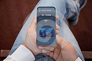 Male hands holding phone with airplane ticket application airlines screen