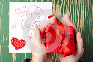 Male hands holding a red Valentines present