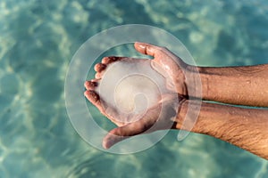 Male hands holding salt from the dead sea