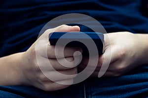 Male hands holding smartphone closeup. Play game, browsing media, communicate or watch online video content.