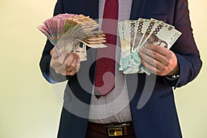 Male hands holding stack of ukrainian hryvnia banknotes isolated on green. Hryvnia new 1000 500 and 200 uah banknotes