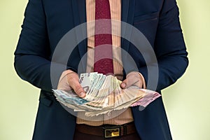 Male hands holding stack of ukrainian hryvnia banknotes isolated on green. Hryvnia new 1000 500 and 200 uah banknotes