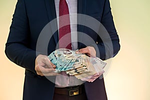 Male hands holding stack of ukrainian hryvnia banknotes isolated on green. Hryvnia new 1000 500 and 200 uah banknotes