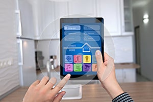 Male hands holding tablet with app smart home kitchen house