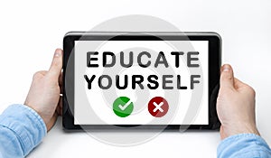 Male hands holding tablet pc with text EDUCATE YOURSELF on white background