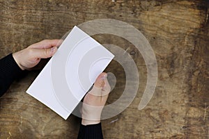 Male hands holding a white blank sheet of paper