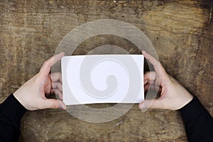 Male hands holding a white blank sheet of paper