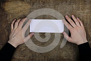 Male hands holding a white blank sheet of paper