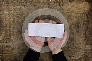 Male hands holding a white blank sheet of paper