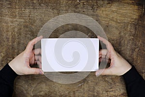 Male hands holding a white blank sheet of paper