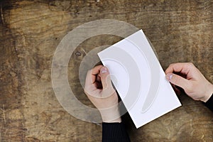 Male hands holding a white blank sheet of paper