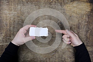 Male hands holding a white blank sheet of paper