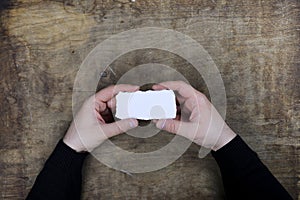 Male hands holding a white blank sheet of paper