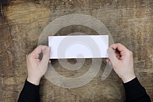 Male hands holding a white blank sheet of paper