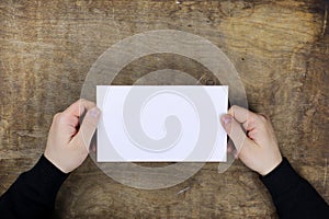 Male hands holding a white blank sheet of paper