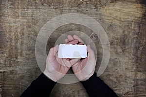 Male hands holding a white blank sheet of paper