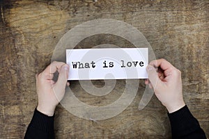 male hands holding a white blank sheet of paper with what is lov