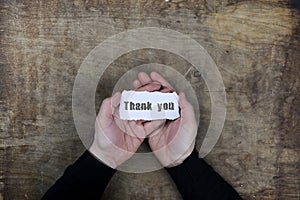 Male hands holding a white blank thank you on sheet of paper