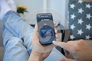 Male hands holds phone with airplane ticket application airlines screen