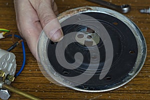 Male hands install a new rubber gasket into the boiler flange