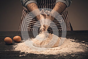 Male hands knead the dough.