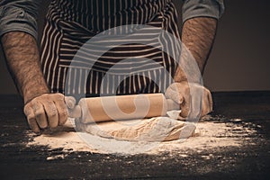 Male hands knead the dough.