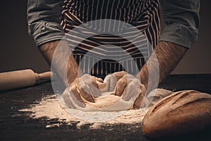 Male hands knead the dough.