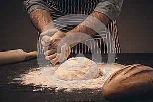 Male hands knead the dough.