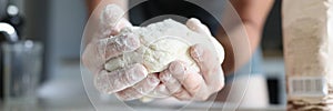 Male hands knead the dough in flour