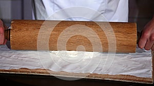 Male hands kneading dough in flour on a table