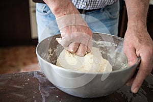 Male hands making bread in kitchen at home