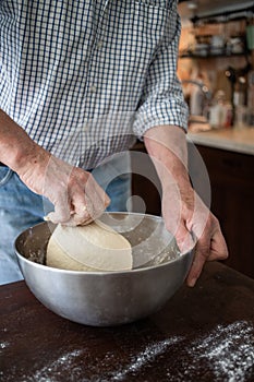 male hands making bread in kitchen at home